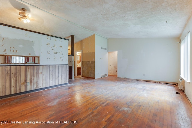 4316 Dumfries Cir, Lansing, MI 48911 - unfurnished living room featuring hardwood / wood-style floors, lofted ceiling, a textured ceiling, and ceiling fan