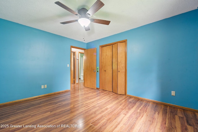 445 S Oak St, Maple Rapids, MI 48853 - unfurnished bedroom featuring baseboards, a closet, wood finished floors, and a ceiling fan