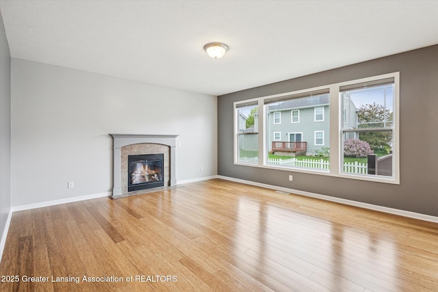 619 Willet Way E, Lansing, MI 48823 - unfurnished living room with wood finished floors, a fireplace, and baseboards