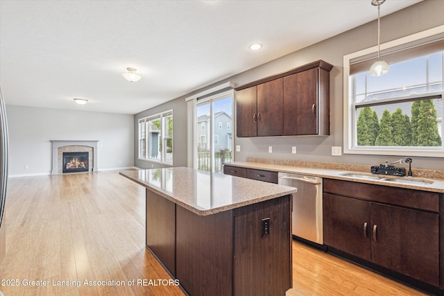 619 Willet Way E, Lansing, MI 48823 - kitchen with dishwasher, a sink, dark brown cabinets, a center island, and a glass covered fireplace