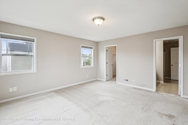 619 Willet Way E, Lansing, MI 48823 - unfurnished bedroom with light colored carpet, baseboards, and a walk in closet