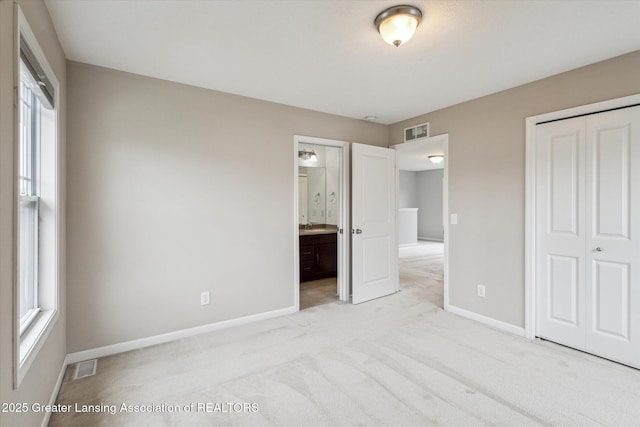 619 Willet Way E, Lansing, MI 48823 - unfurnished bedroom with a closet, baseboards, carpet, and ensuite bathroom