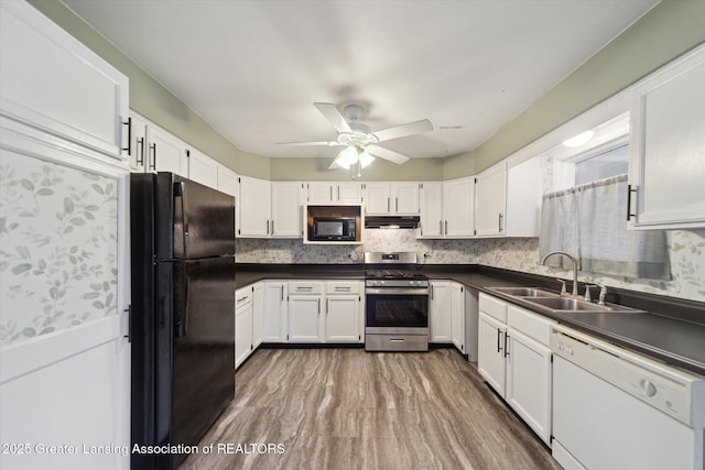 139 W Mansion St, Jackson, MI 49203 - kitchen featuring black appliances, under cabinet range hood, a sink, and dark countertops