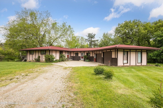 7161 E Eaton Hwy, Mulliken, MI 48861 - view of front of house featuring driveway, a front yard, and stucco siding