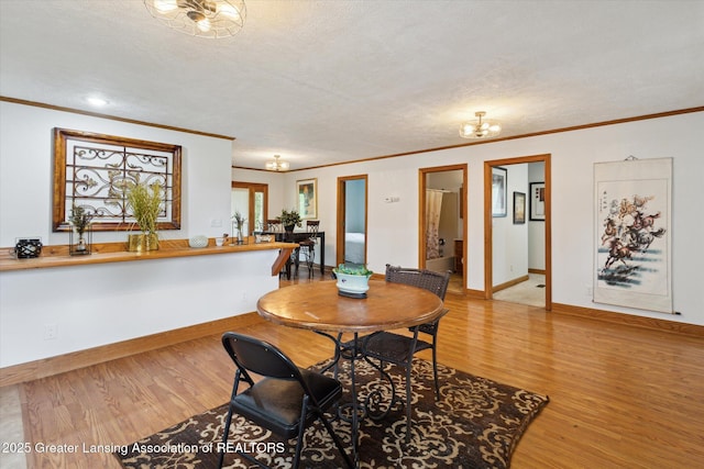 7161 E Eaton Hwy, Mulliken, MI 48861 - dining room with crown molding, wood finished floors, baseboards, and a textured ceiling