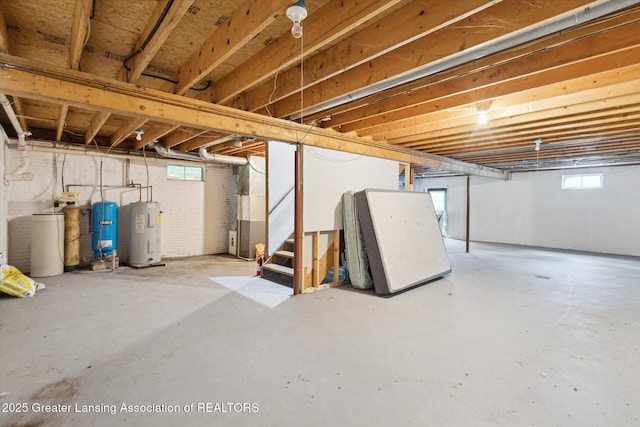 7161 E Eaton Hwy, Mulliken, MI 48861 - below grade area with electric water heater, a water softener system, stairs, heating unit, and a water pressure tank