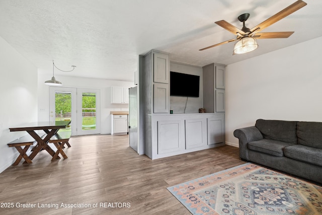 114 Walker Dr, Morrice, MI 48857 - living area featuring a ceiling fan, light wood-style floors, and baseboards