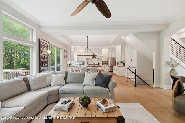 16851 Meadowbrook Dr, Haslett, MI 48840 - living area with plenty of natural light, ceiling fan, light wood-style flooring, crown molding, and a chandelier