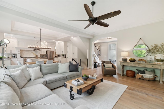 16851 Meadowbrook Dr, Haslett, MI 48840 - living room with light wood-type flooring, ornamental molding, arched walkways, a ceiling fan, and a chandelier