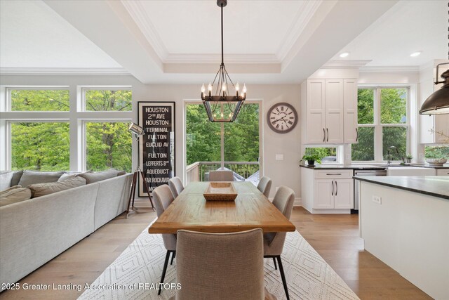 16851 Meadowbrook Dr, Haslett, MI 48840 - dining area featuring a chandelier, healthy amount of natural light, crown molding, light wood-style flooring, and a raised ceiling