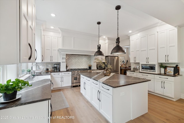 16851 Meadowbrook Dr, Haslett, MI 48840 - kitchen featuring high end appliances, tasteful backsplash, a kitchen island, ornamental molding, and white cabinets