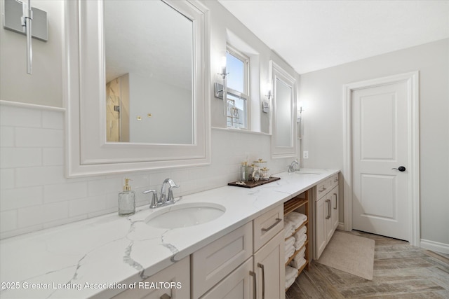 16851 Meadowbrook Dr, Haslett, MI 48840 - bathroom featuring double vanity, tasteful backsplash, and wood finished floors