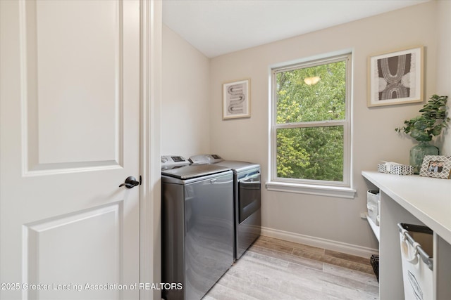 16851 Meadowbrook Dr, Haslett, MI 48840 - laundry room featuring separate washer and dryer, light wood finished floors, and baseboards
