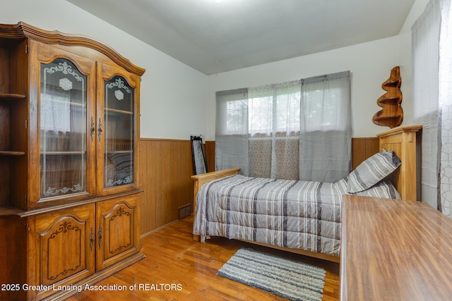 15157 Chetwyn Dr, Lansing, MI 48906 - bedroom featuring a wainscoted wall, wooden walls, and wood finished floors
