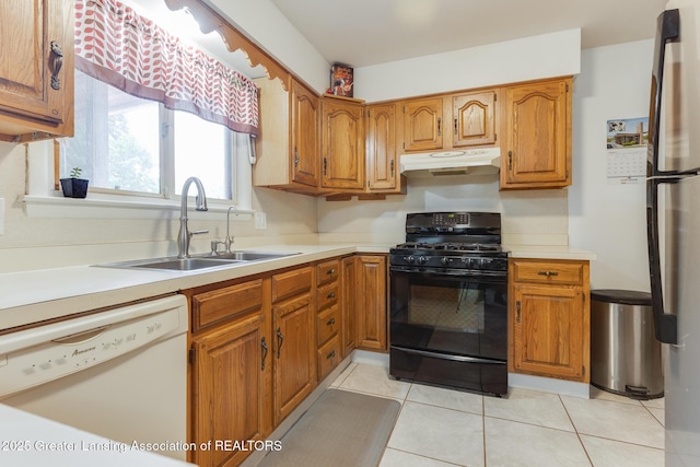 15157 Chetwyn Dr, Lansing, MI 48906 - kitchen with black gas stove, white dishwasher, under cabinet range hood, a sink, and brown cabinetry