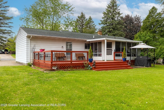 15157 Chetwyn Dr, Lansing, MI 48906 - rear view of house with a sunroom, a deck, a chimney, a yard, and driveway