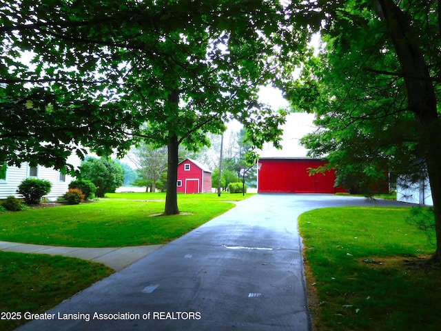 2229 Ives Rd, Leslie, MI 49251 - view of front facade with a barn, a front yard, an outdoor structure, and driveway