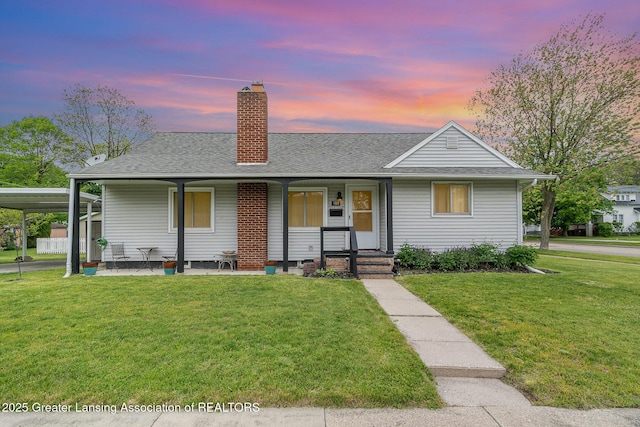 504 Iowa St, Alma, MI 48801 - view of front of home with a chimney, a lawn, a porch, roof with shingles, and a carport