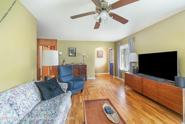 504 Iowa St, Alma, MI 48801 - living room featuring arched walkways, ceiling fan, light wood finished floors, and baseboards