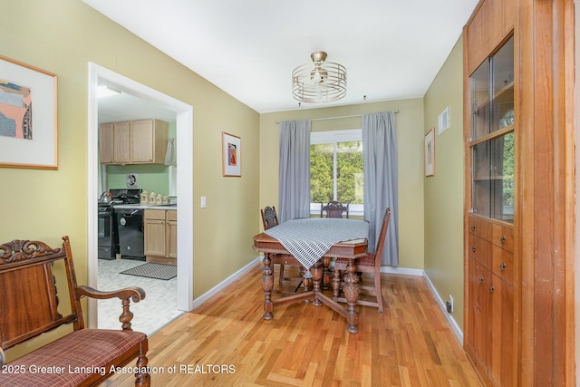 504 Iowa St, Alma, MI 48801 - dining area with light wood-style floors, baseboards, and a chandelier