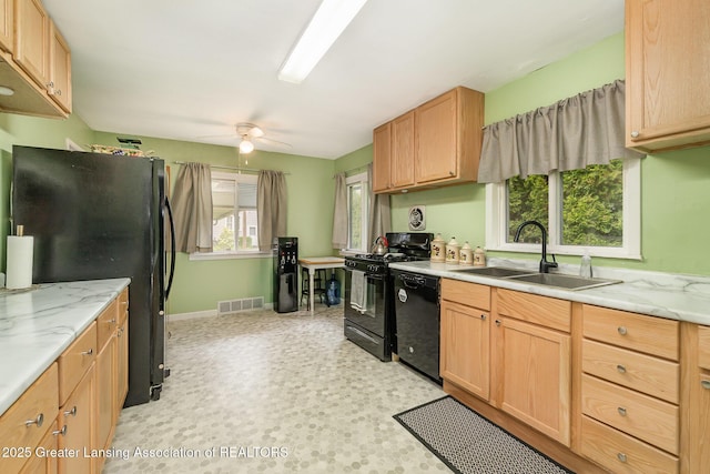 504 Iowa St, Alma, MI 48801 - kitchen with a sink, black appliances, a ceiling fan, baseboards, and light floors