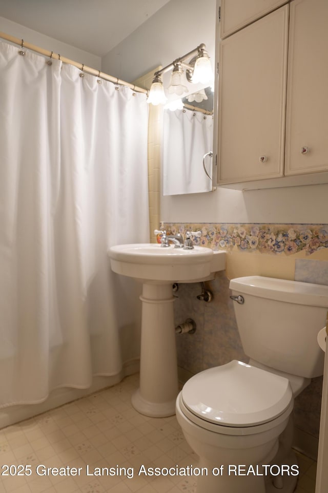 1720 Quentin Ave, Lansing, MI 48910 - bathroom featuring toilet, tile patterned floors, and a sink