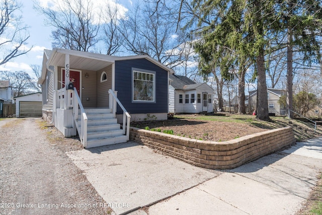 620 Irvington Ave, Lansing, MI 48910 - view of front facade featuring an outbuilding, gravel driveway, and a detached garage