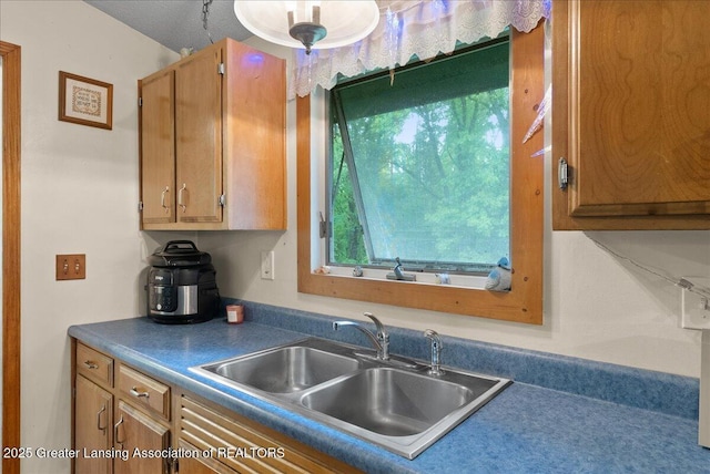 8279 Tyrrell Rd, Laingsburg, MI 48848 - kitchen with a sink, dark countertops, and brown cabinetry