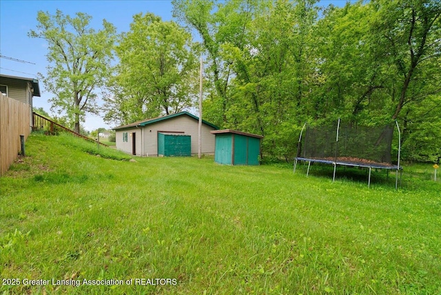 8279 Tyrrell Rd, Laingsburg, MI 48848 - view of grassy yard with a trampoline and a garage