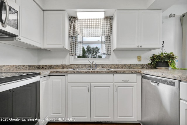 6415 Creyts Rd, Dimondale, MI 48821 - kitchen with stainless steel appliances, a sink, and white cabinetry