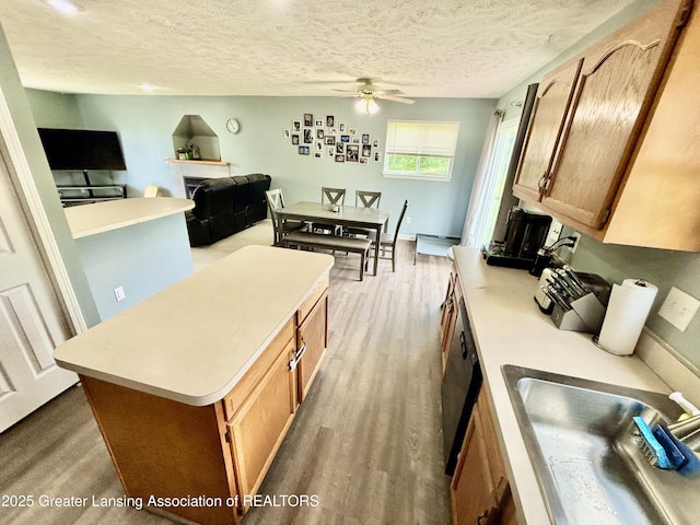 405 N Iris Ln, Laingsburg, MI 48848 - kitchen featuring a sink, ceiling fan, light countertops, a textured ceiling, and brown cabinetry