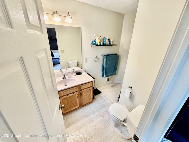 405 N Iris Ln, Laingsburg, MI 48848 - ensuite bathroom featuring toilet, vanity, and tile patterned flooring
