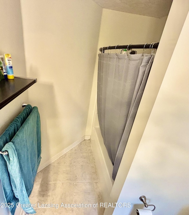 405 N Iris Ln, Laingsburg, MI 48848 - bathroom with baseboards, shower / tub combo, and tile patterned flooring