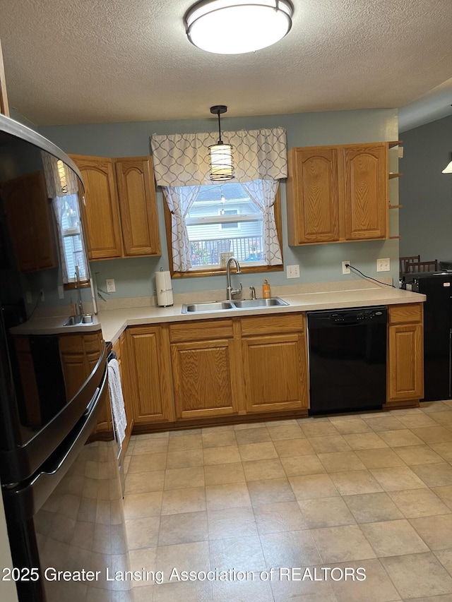 623 Horatio St, Charlotte, MI 48813 - kitchen featuring black dishwasher, a sink, a textured ceiling, light countertops, and decorative light fixtures