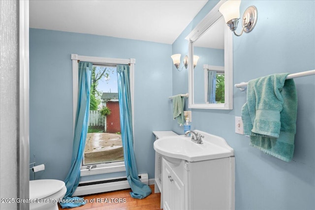 218 Russell St, Grand Ledge, MI 48837 - bathroom featuring vanity, a baseboard radiator, toilet, and wood finished floors