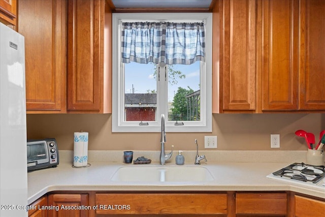 218 Russell St, Grand Ledge, MI 48837 - kitchen with a sink, light countertops, white appliances, and healthy amount of natural light