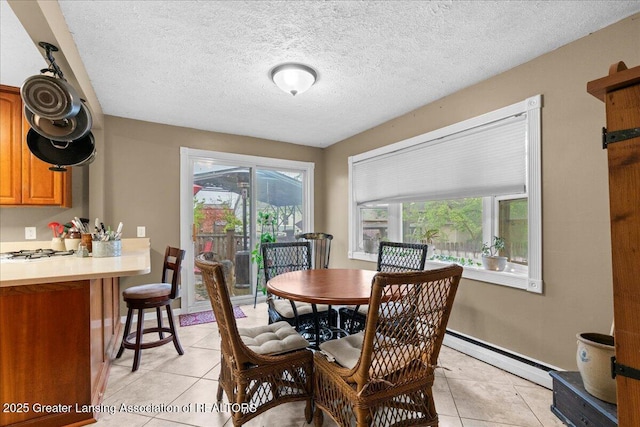 218 Russell St, Grand Ledge, MI 48837 - dining area featuring light tile patterned floors, a baseboard heating unit, baseboards, and a textured ceiling