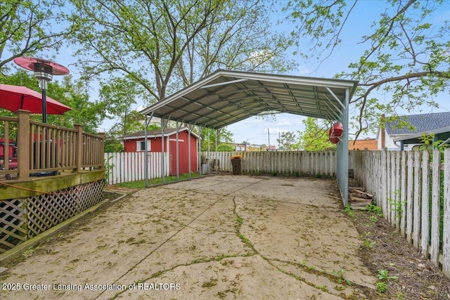218 Russell St, Grand Ledge, MI 48837 - fenced backyard featuring a carport, driveway, and a wooden deck