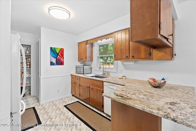 420 John R St, East Lansing, MI 48823 - kitchen featuring a sink, white appliances, brown cabinets, baseboards, and light stone counters