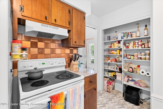 420 John R St, East Lansing, MI 48823 - kitchen featuring white range with electric cooktop, under cabinet range hood, decorative backsplash, light countertops, and brown cabinets