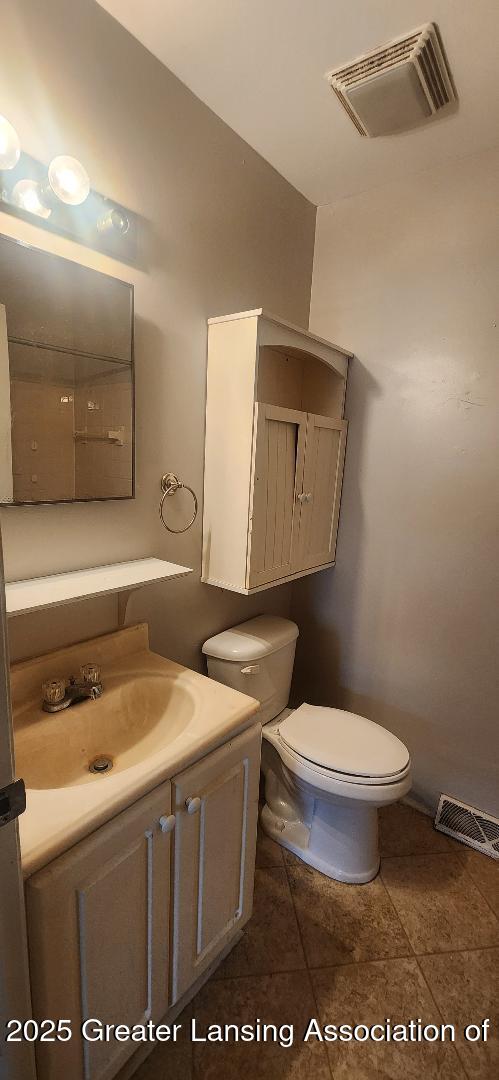 6622 Aurelius Rd, Lansing, MI 48911 - half bathroom featuring toilet, vanity, and tile patterned flooring