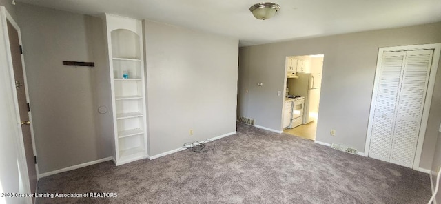 6622 Aurelius Rd, Lansing, MI 48911 - unfurnished bedroom with light carpet, baseboards, a closet, and freestanding refrigerator