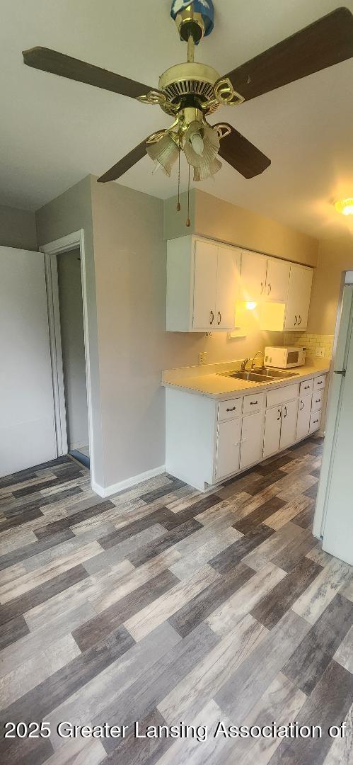 6622 Aurelius Rd, Lansing, MI 48911 - kitchen with white appliances, light countertops, white cabinetry, a ceiling fan, and a sink