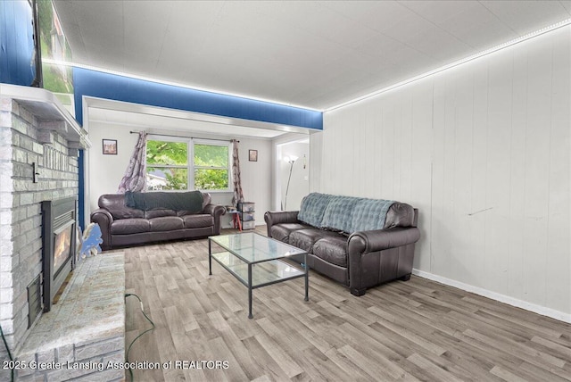 407 Kearney St, Portland, MI 48875 - living room featuring wood finished floors and a brick fireplace