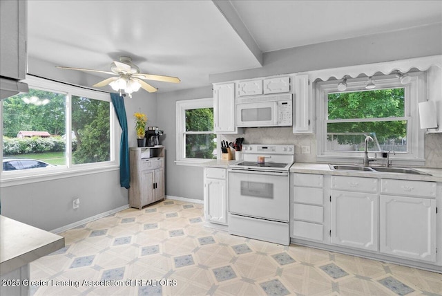 407 Kearney St, Portland, MI 48875 - kitchen featuring white appliances, a sink, light countertops, and white cabinetry