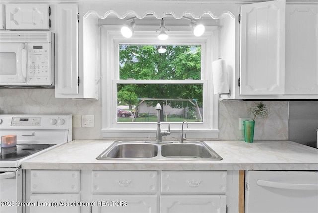 407 Kearney St, Portland, MI 48875 - kitchen featuring white appliances, a sink, light countertops, white cabinetry, and backsplash
