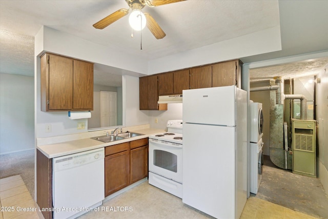 820 Kenwood Ave, Lansing, MI 48910 - kitchen featuring white appliances, a sink, under cabinet range hood, light countertops, and brown cabinetry
