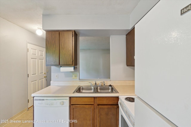 820 Kenwood Ave, Lansing, MI 48910 - kitchen featuring white appliances, a sink, light countertops, and brown cabinets