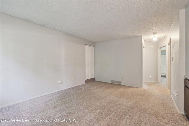 820 Kenwood Ave, Lansing, MI 48910 - unfurnished room featuring light carpet, a textured ceiling, and baseboards