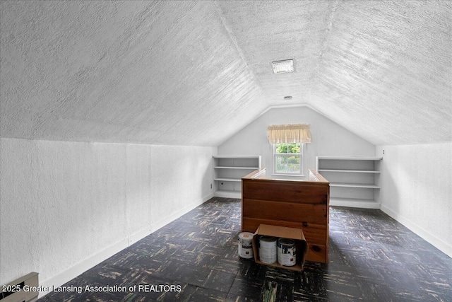 1218 Woodbine Ave, Lansing, MI 48910 - additional living space featuring a textured ceiling, lofted ceiling, a textured wall, and baseboards